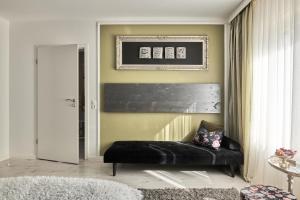 ein Wohnzimmer mit einem schwarzen Sofa und einer Wand in der Unterkunft Aparthotel Voglergasse in Baden-Baden