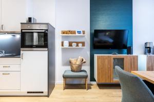 a kitchen with a tv and a chair and a table at Ferienapartments am Krusespeicher Ferienapartments am Krusespeicher 2-21 in Wismar
