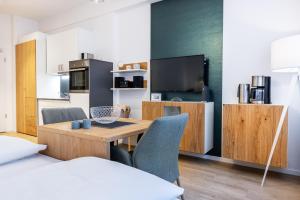 ein Zimmer mit Tisch und Stühlen und eine Küche in der Unterkunft Ferienapartments am Krusespeicher Ferienapartments am Krusespeicher 1-12 in Wismar