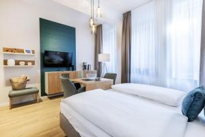a hotel room with a bed and a desk and a tv at Ferienapartments am Krusespeicher Ferienapartments am Krusespeicher 2-21 in Wismar