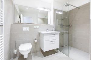 a white bathroom with a toilet and a shower at Ferienapartments am Krusespeicher Ferienapartments am Krusespeicher 2-21 in Wismar +12 photos