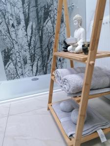 een houten ladder met handdoeken in de badkamer bij Kőkert Delux Pihenőház in Kőszeg