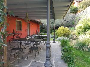 a patio with tables and chairs under an umbrella at B&B La Casaccia in Verbania +8 photos