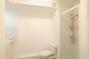 a white bathroom with a toilet and a shower at Résidence Nemea Aix Campus 2 in Aix-en-Provence