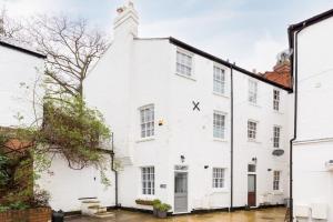 a white building with a clock on the side of it at The Old Morgan Period Town House in Great Malvern