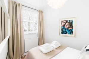 a white bedroom with two towels on a bed at The Old Morgan Period Town House in Great Malvern