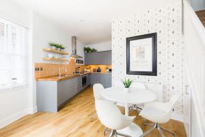 a kitchen with a white table and white chairs at The Old Morgan Period Town House in Great Malvern