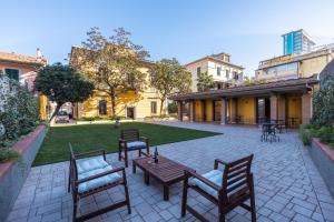 a patio with a table and chairs and a lawn at B&B Follonica in Follonica