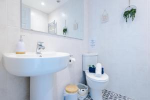 a white bathroom with a sink and a toilet at Pristine 2-bed house in Chester by 53 Degrees Property, ideal for Families & Small groups, Great Location - Sleeps 6 in Hough Green +22 photos