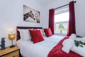 a bedroom with a bed with red pillows and a window at Pristine 2-bed house in Chester by 53 Degrees Property, ideal for Families & Small groups, Great Location - Sleeps 6 in Hough Green