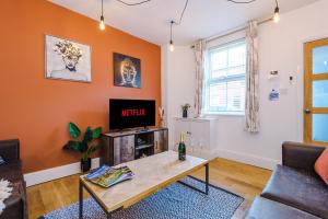 a living room with a table and a tv at Pristine 2-bed house in Chester by 53 Degrees Property, ideal for Families & Small groups, Great Location - Sleeps 6 in Hough Green