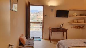 a room with a bed and a table and a window at Maso al Sole Agriturismo in Civezzano