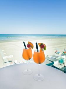 due cocktail seduti su un tavolo in spiaggia di Riviera Mare Beach Life Hotel a Rimini