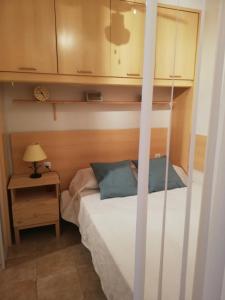 a bedroom with a bunk bed and a night stand with a lamp at Acogedor estudio con vistas al mar 1ªLínea in Bellreguart