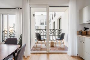 Il comprend une cuisine et une salle à manger avec des portes coulissantes s'ouvrant sur un balcon. dans l'établissement Edgar Suites Châtillon, à Châtillon