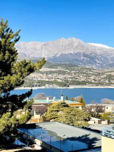 a view of a lake with a mountain in the background at Appartement lumineux proche plage et parking in Savines
