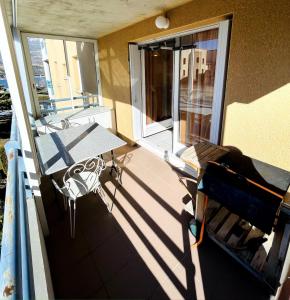 - un balcon avec une table et des chaises dans l'établissement Appartement lumineux proche plage et parking, à Savines