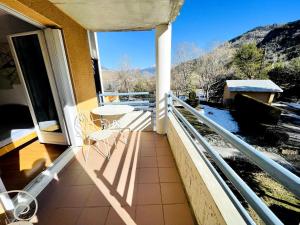 a balcony of a house with a table and chairs at Appartement lumineux proche plage et parking in Savines