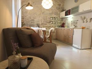 ein Wohnzimmer mit einem Sofa und einer Küche in der Unterkunft Leut Apartment in Korčula