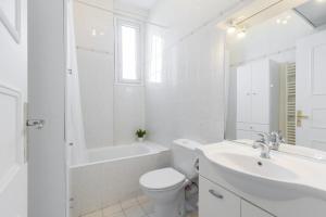 biała łazienka z toaletą, umywalką i wanną w obiekcie Open view Swimming Pool & Garage 1 Bdr w Nicei