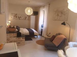 a bedroom with a bed and a couch and a chair at Leut Apartment in Korčula