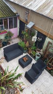 an outdoor patio with black furniture and potted plants at Lecerf in Condé-sur-Noireau