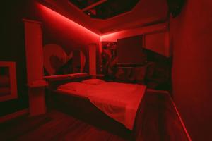 ein rotes Zimmer mit einem Bett mit roter Lampe in der Unterkunft Motel Príncipe Encantado in Mealhada