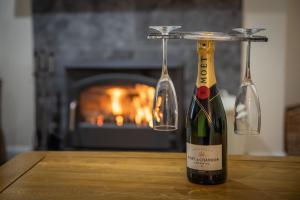 a bottle of wine on a table in front of a fireplace at Cliff Walk Cottage in Arbroath