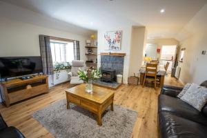 uma sala de estar com um sofá e uma mesa de centro em Cliff Walk Cottage em Arbroath