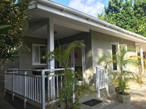 a house with palm trees in front of it at Sunbird Bungalow in Anse Boileau