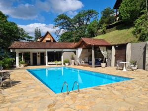 a swimming pool in front of a house at Pousada Serra da Índia in Penedo