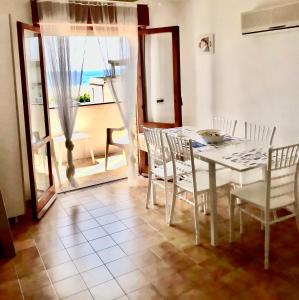 een eetkamer met een tafel en stoelen en een raam bij Casa Vacanza Grisolia Lido in Grisolia