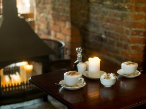 two cups of coffee and candles on a wooden table at The White Horse Inn in Eye