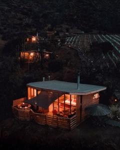 a house with a roof on a hill at night at Origen del Maipo Lodge in San José de Maipo