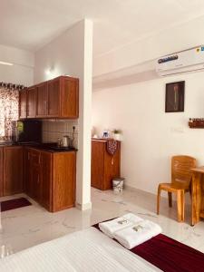 una cocina con armarios de madera y una mesa en una habitación en DOLPHIN ENCLAVE SERVICE STUDIO APARTMENTS en Kalpatta