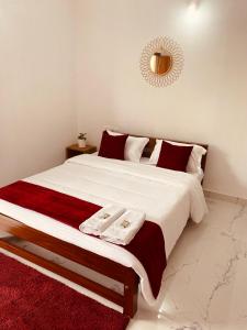 cama grande con sábanas rojas y blancas y espejo en DOLPHIN ENCLAVE SERVICE STUDIO APARTMENTS en Kalpatta