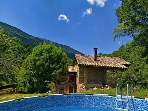 uma casa e uma piscina em frente a uma casa em Molí de Dalt em La Coma i la Pedra