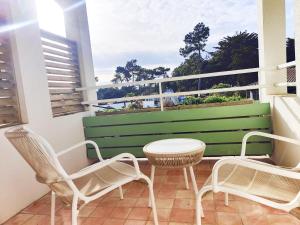 a balcony with chairs and a table and a window at Hôtel Les Grenettes in Sainte-Marie-de-Ré