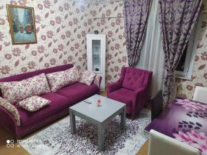 a living room with a purple couch and two chairs at Üsküdar halk caddesi in Istanbul