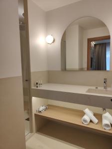 a bathroom with a sink and a mirror at Hôtel Les Grenettes in Sainte-Marie-de-Ré