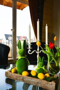 two stuffed rabbits sitting on a table with candles at Okno na gorce in Frydman