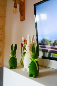 two green rabbits sitting on a shelf next to a tv at Okno na gorce in Frydman