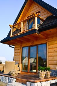a log cabin with a balcony on top of it at Okno na gorce in Frydman