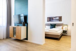 a bedroom with a bed and a flat screen tv at Ferienapartments am Krusespeicher Ferienapartments am Krusespeicher 3-25 in Wismar