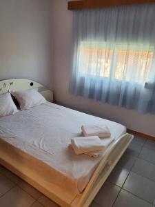 uma cama com toalhas num quarto com uma janela em Villa Borisa em Paralía Avdhíron
