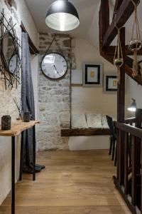 joli appartement 2 pers dans les remparts de Guérande في غيراند: غرفة بها ساعة كبيرة على الحائط