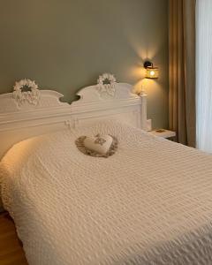 a white bed with a heart shaped pillow on it at La maison Virginie log 1 à 2 pers charmant hyper centre parking linge wifi proximité lac canal piscine in Montargis