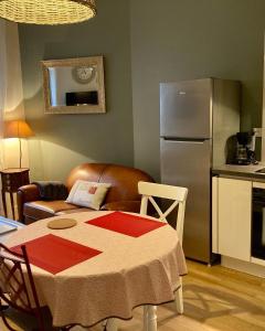 uma cozinha com uma mesa e um frigorífico em La maison Virginie log 1 à 2 pers charmant hyper centre parking linge wifi proximité lac canal piscine em Montargis