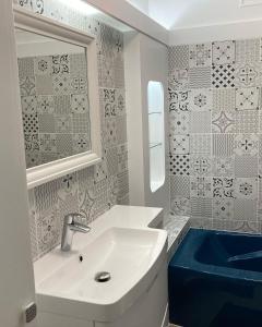 uma casa de banho com um lavatório branco e uma banheira azul em La maison Virginie log 1 à 2 pers charmant hyper centre parking linge wifi proximité lac canal piscine em Montargis