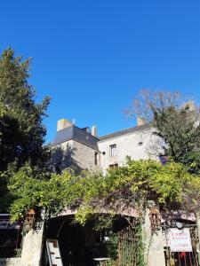 un grand bâtiment blanc avec des arbres devant lui dans l'établissement joli appartement 2 pers dans les remparts de Guérande, à Guérande